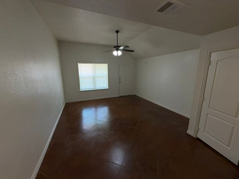 Empty room with brown floor and white walls.