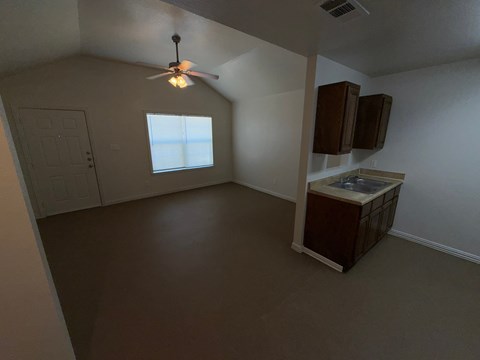 A room with a ceiling fan and a window.