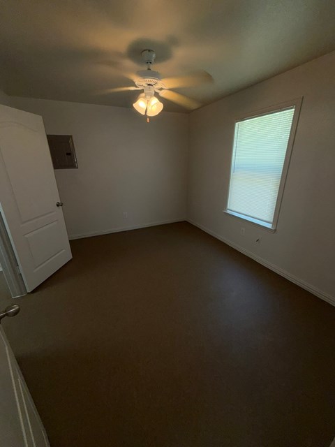 A room with a ceiling fan and a window.