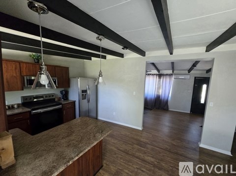 A kitchen with a granite countertop and a refrigerator.