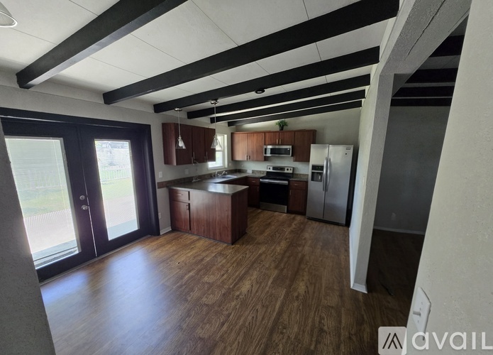 A kitchen with wooden floors and a refrigerator.