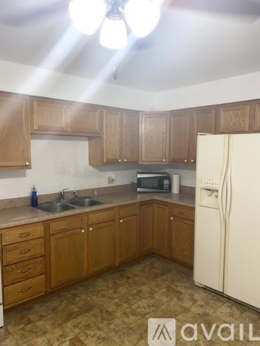 A kitchen with wooden cabinets and a white refrigerator.
