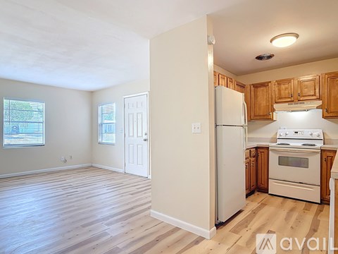A kitchen with wooden cabinets and a white refrigerator.