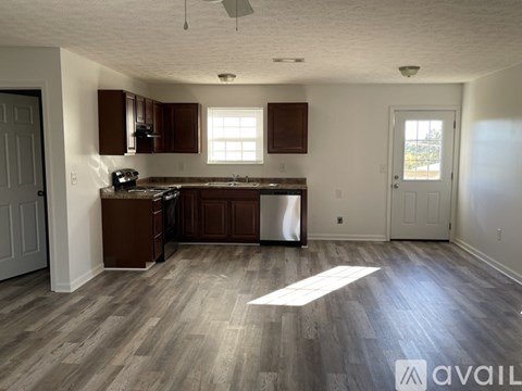 A kitchen with wooden cabinets and a stainless steel dishwasher.