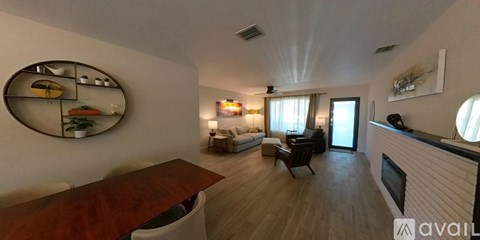 A living room with a wooden table and a mirror on the wall.
