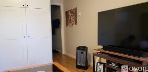 A black television is on a wooden stand in a living room.