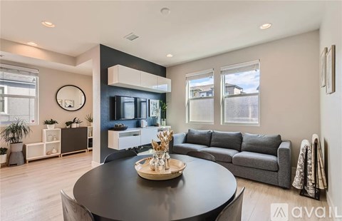 A modern living room with a black coffee table and grey sofa.
