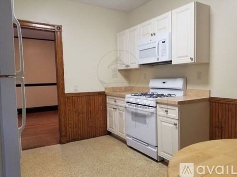 A kitchen with a white stove and cabinets.
