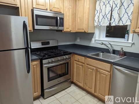 A kitchen with wooden cabinets and a stainless steel refrigerator.