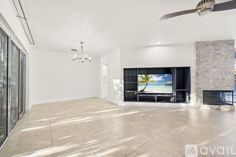 A spacious living room with a fireplace and a television displaying a beach scene.