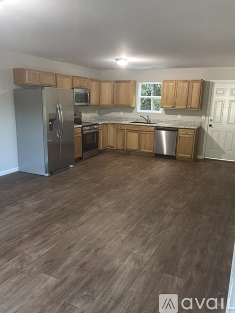 A kitchen with wooden cabinets and a refrigerator.