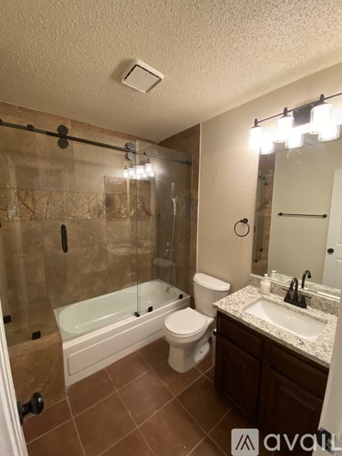 A bathroom with brown tiles and a white sink.