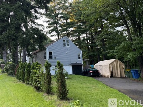 A house with a grey roof and a car parked in front.