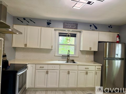 A kitchen with white cabinets and a window above the sink.