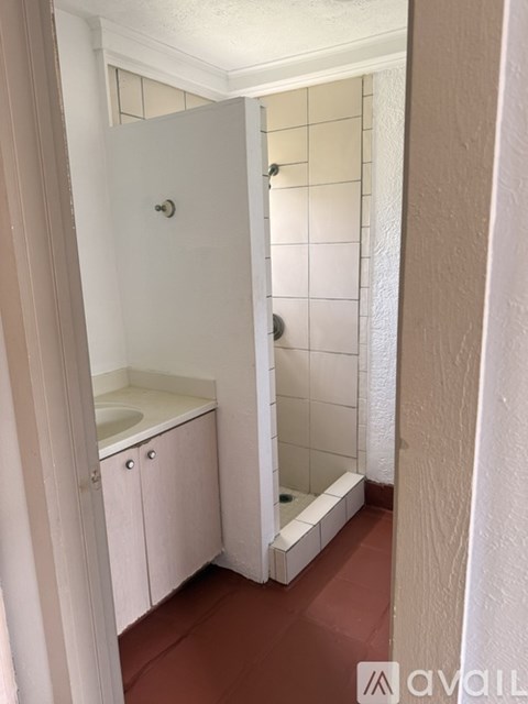 A bathroom with a white cabinet and a white shower.