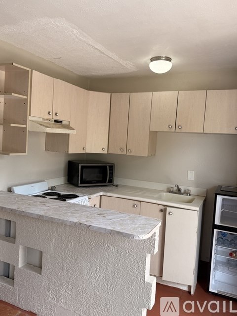 A kitchen with a microwave, sink, and refrigerator.