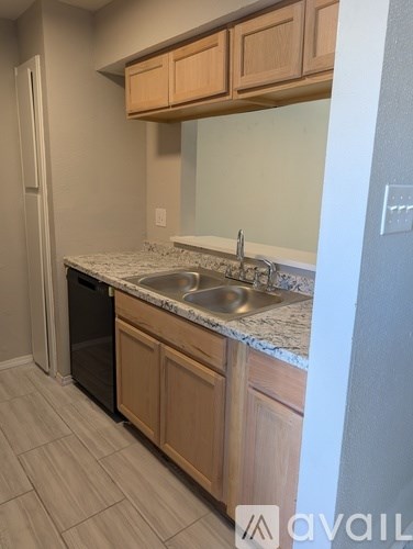 A kitchen with wooden cabinets and a granite countertop.