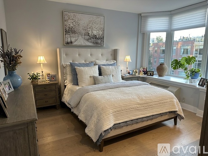 A bedroom with a large bed and a wooden dresser.