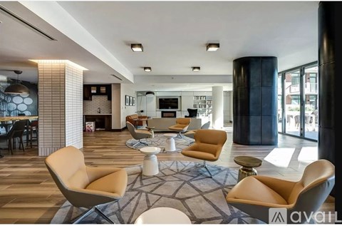 A living room with a large rug and chairs.