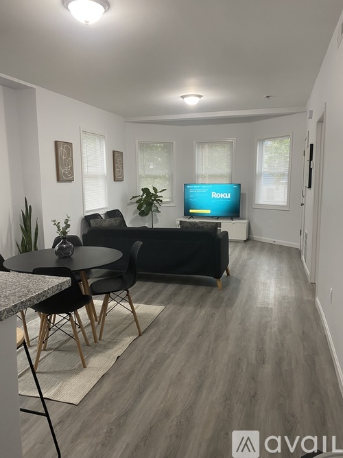 A living room with a black couch and a television displaying the word "Roku".