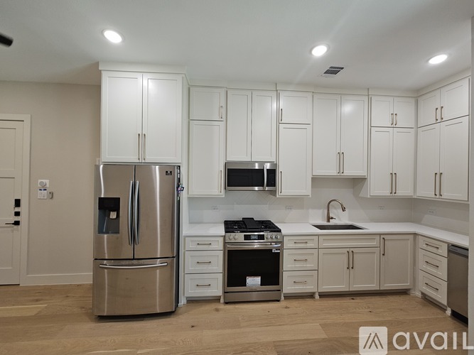A kitchen with white cabinets and stainless steel appliances.