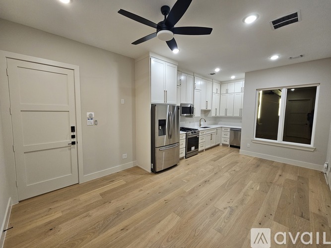 A kitchen with white cabinets and a wooden floor.