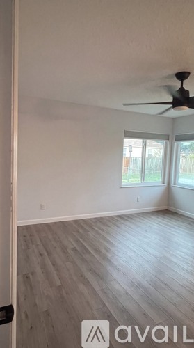 A room with a fan and a window.