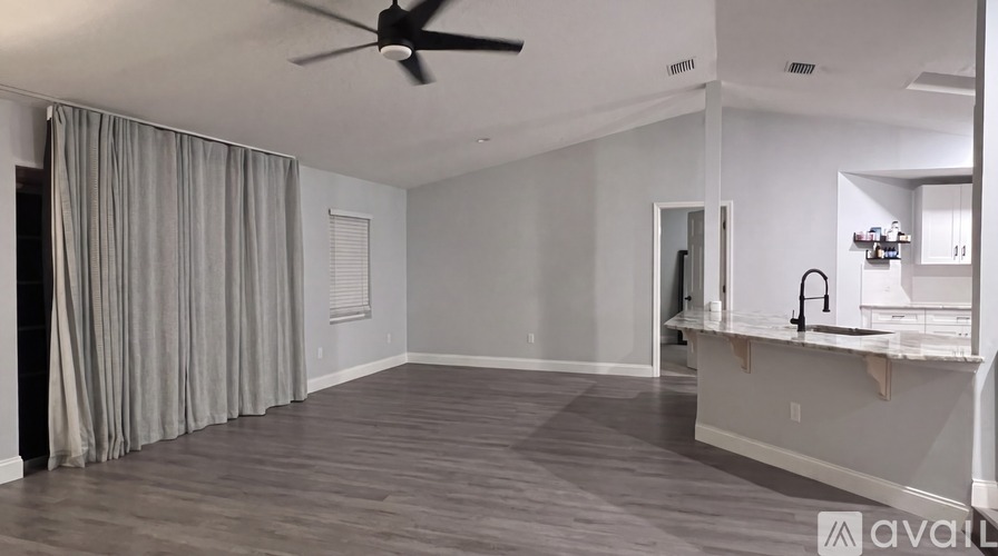 A spacious room with a ceiling fan and a large mirror on the wall.