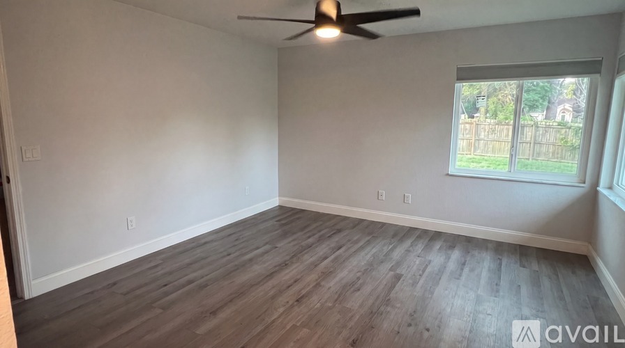 A room with a ceiling fan and a window.