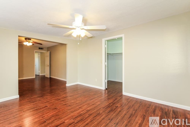 A room with wooden floors and a ceiling fan.