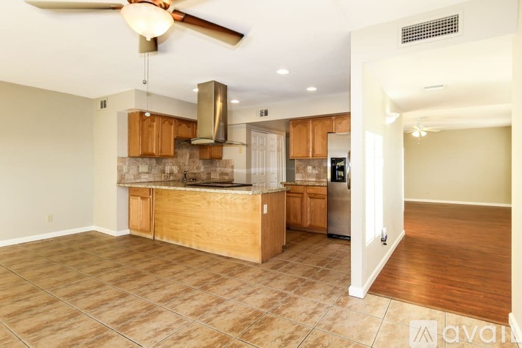 A kitchen with wooden cabinets and a fan on the ceiling.