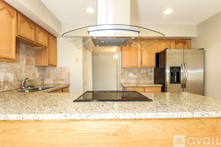 A modern kitchen with wooden cabinets and granite countertops.