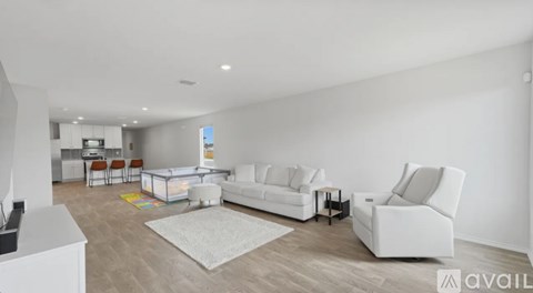 A living room with white furniture and a white couch.
