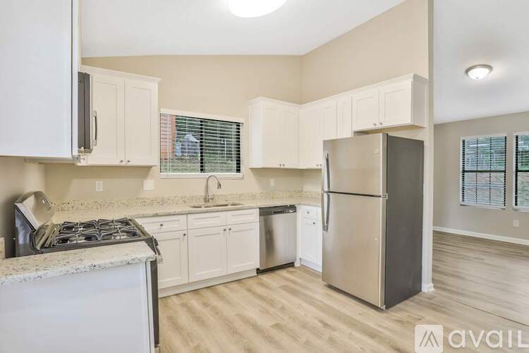 A kitchen with a stove, sink, and refrigerator.