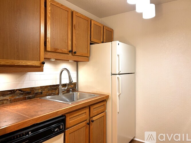 A kitchen with wooden cabinets and a white refrigerator.