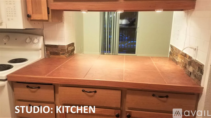 A kitchen with wooden cabinets and a stove top oven.