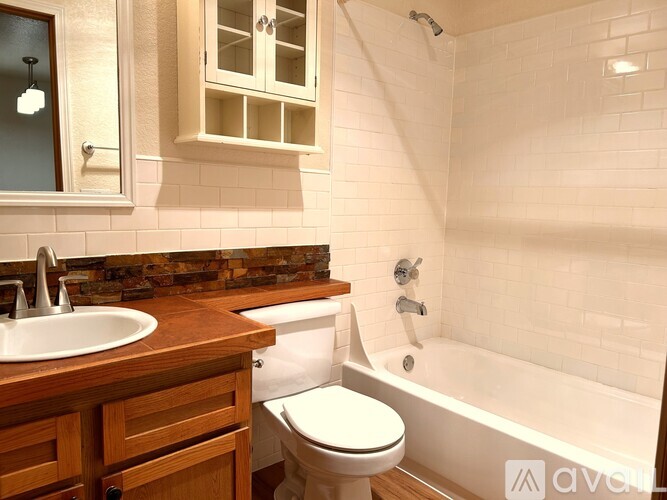 A white toilet sits next to a bathtub in a bathroom.