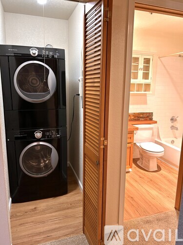 A black front loading washing machine in a small room.