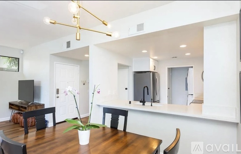 A modern kitchen with a wooden table and chairs.