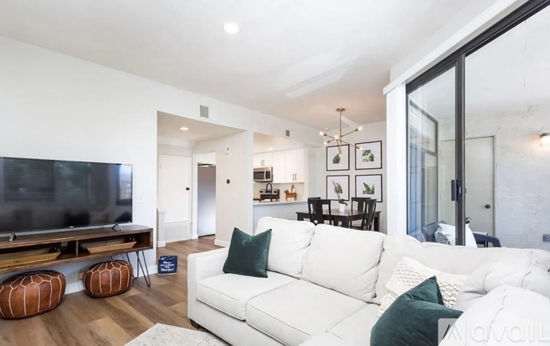 A modern living room with a white couch and a television.