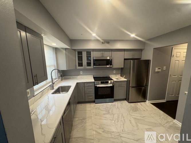 A kitchen with a refrigerator, oven, and sink.