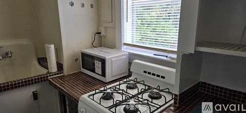 A white microwave oven is sitting on a stove in a kitchen.