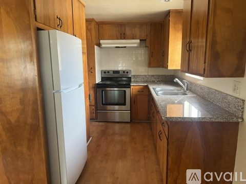 A kitchen with wooden cabinets and a granite countertop.