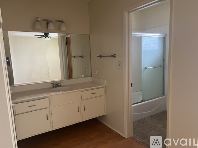 A bathroom with a sink, mirror, and cabinets.