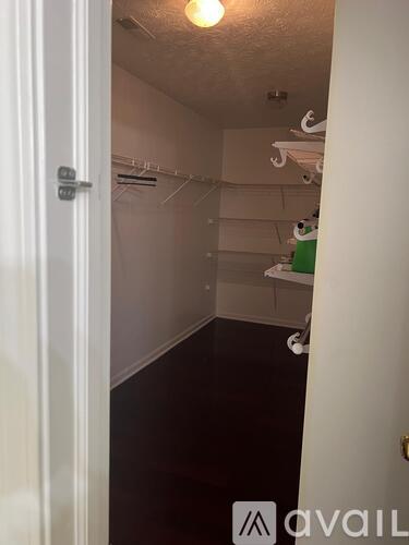 A white door with a silver handle is open to a dark hallway.