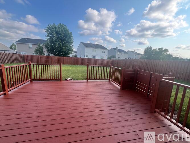 A wooden deck with a railing and a view of a residential area.