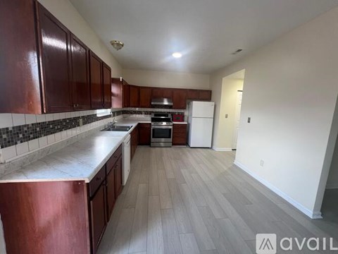 A kitchen with dark brown cabinets and a white countertop.
