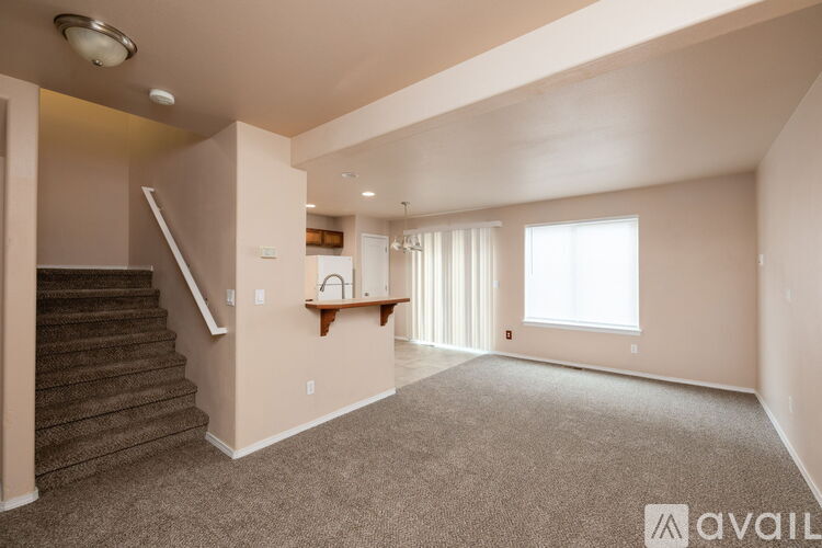 A spacious living room with a staircase leading to the upper floor.