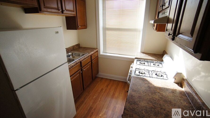 A kitchen with a white refrigerator and wooden cabinets.
