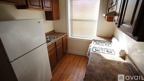 A kitchen with a white refrigerator and wooden cabinets.